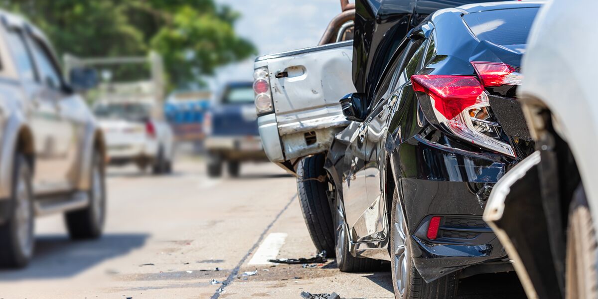 Carro preto batido em acidente de trânsito.
