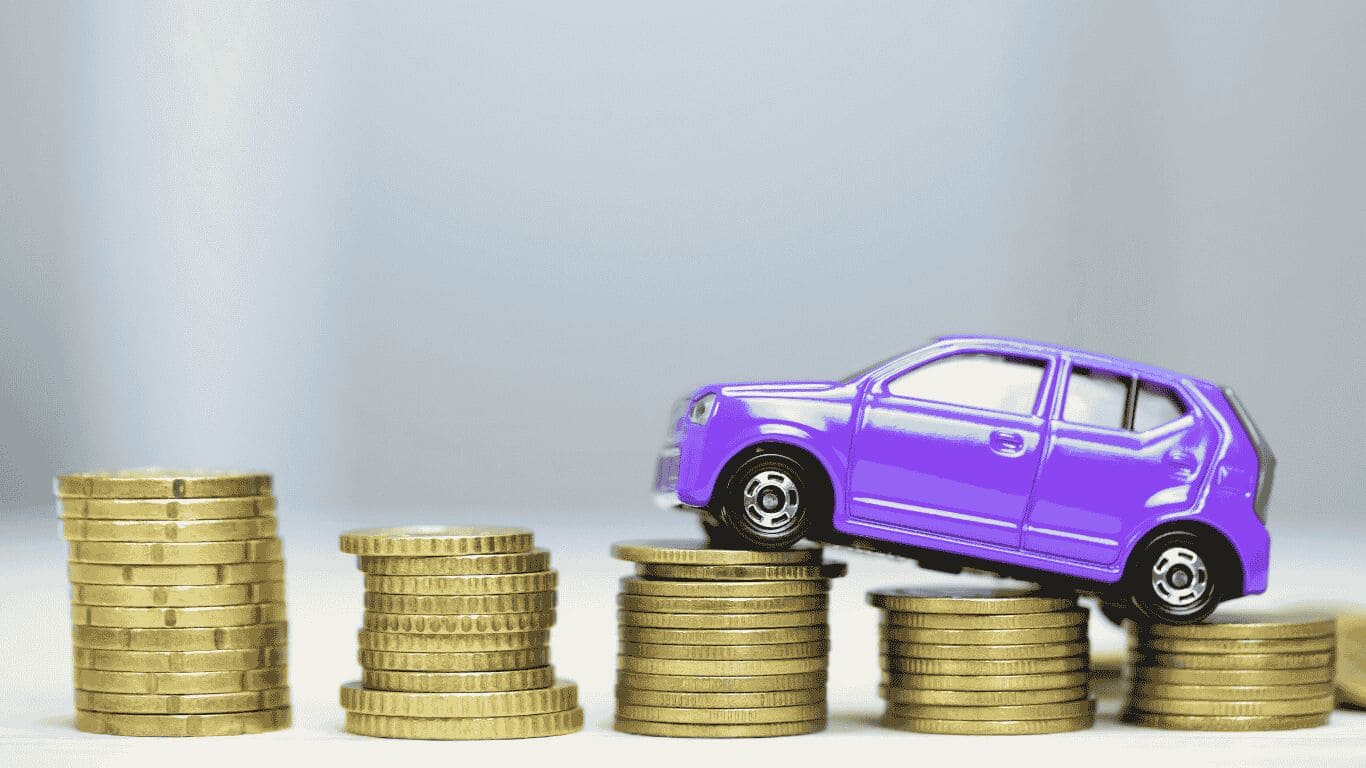 Carro miniatura roxo sobre pilhas de moedas