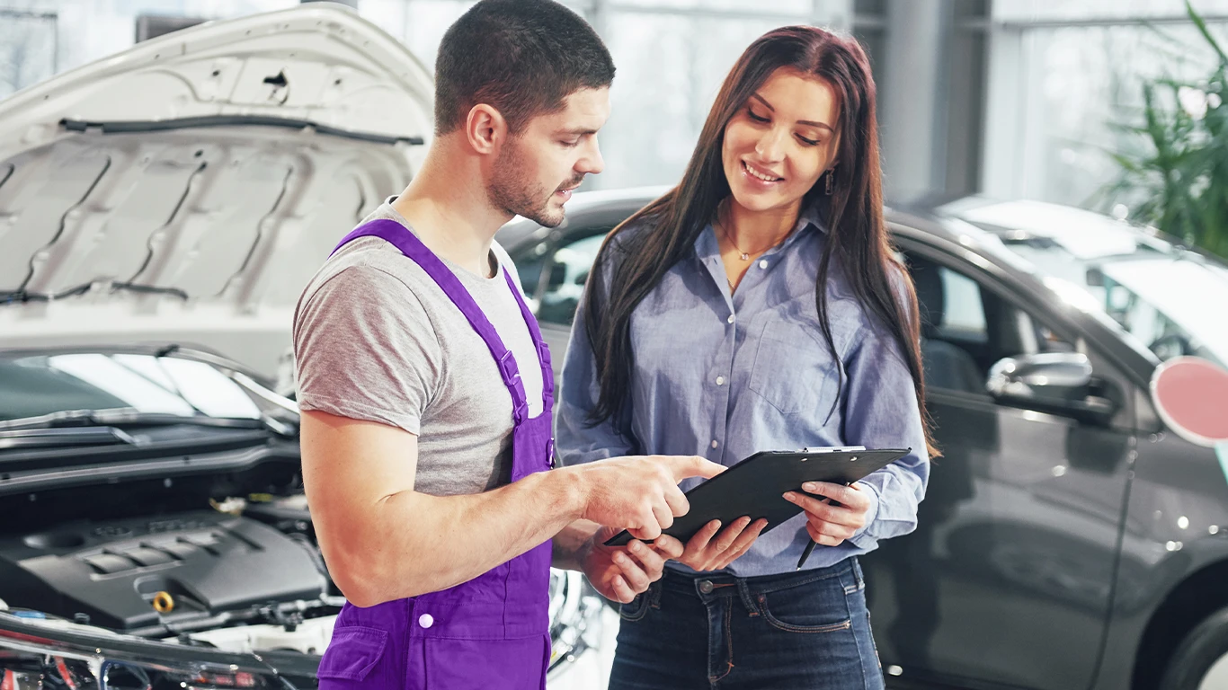 Mecânico explicando serviço a cliente satisfeita