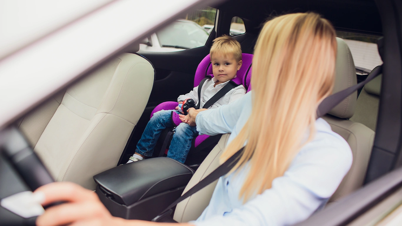 Mãe ajustando cinto de segurança em criança no carro