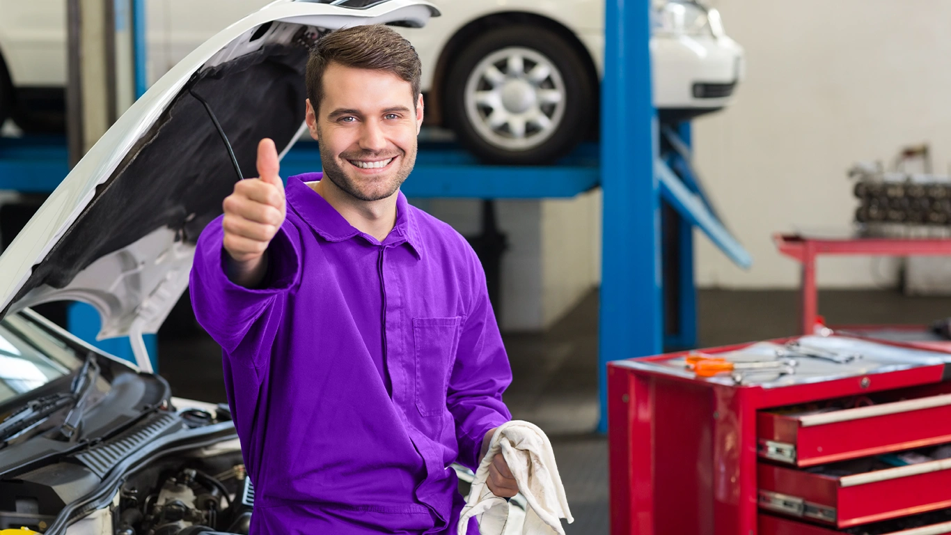 Mecânico sorridente em oficina automobilística