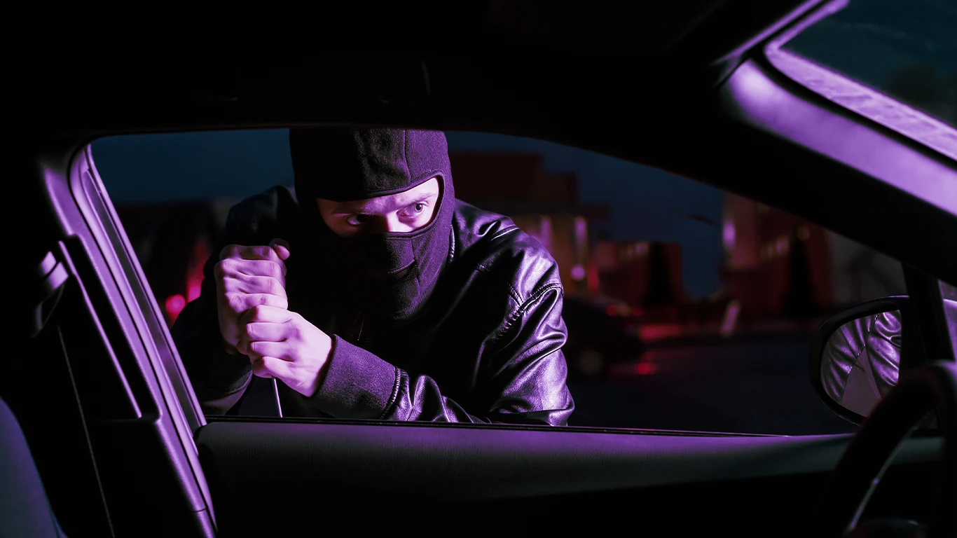 Ladrão tentando roubar um carro à noite