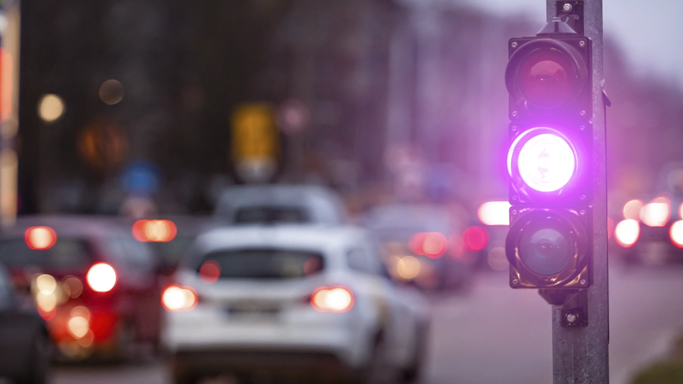 Semáforo aceso com sinal roxo em área urbana