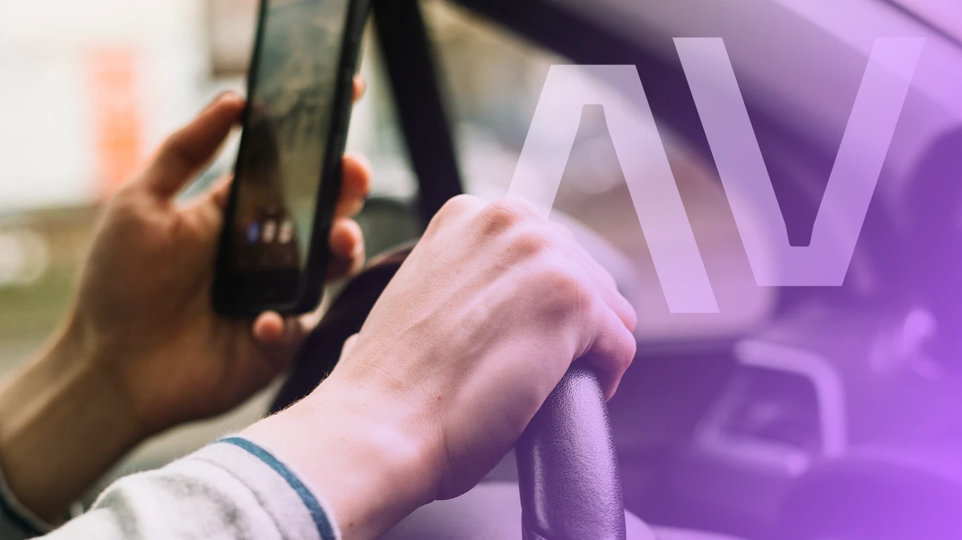 Motorista usando smartphone ao dirigir.