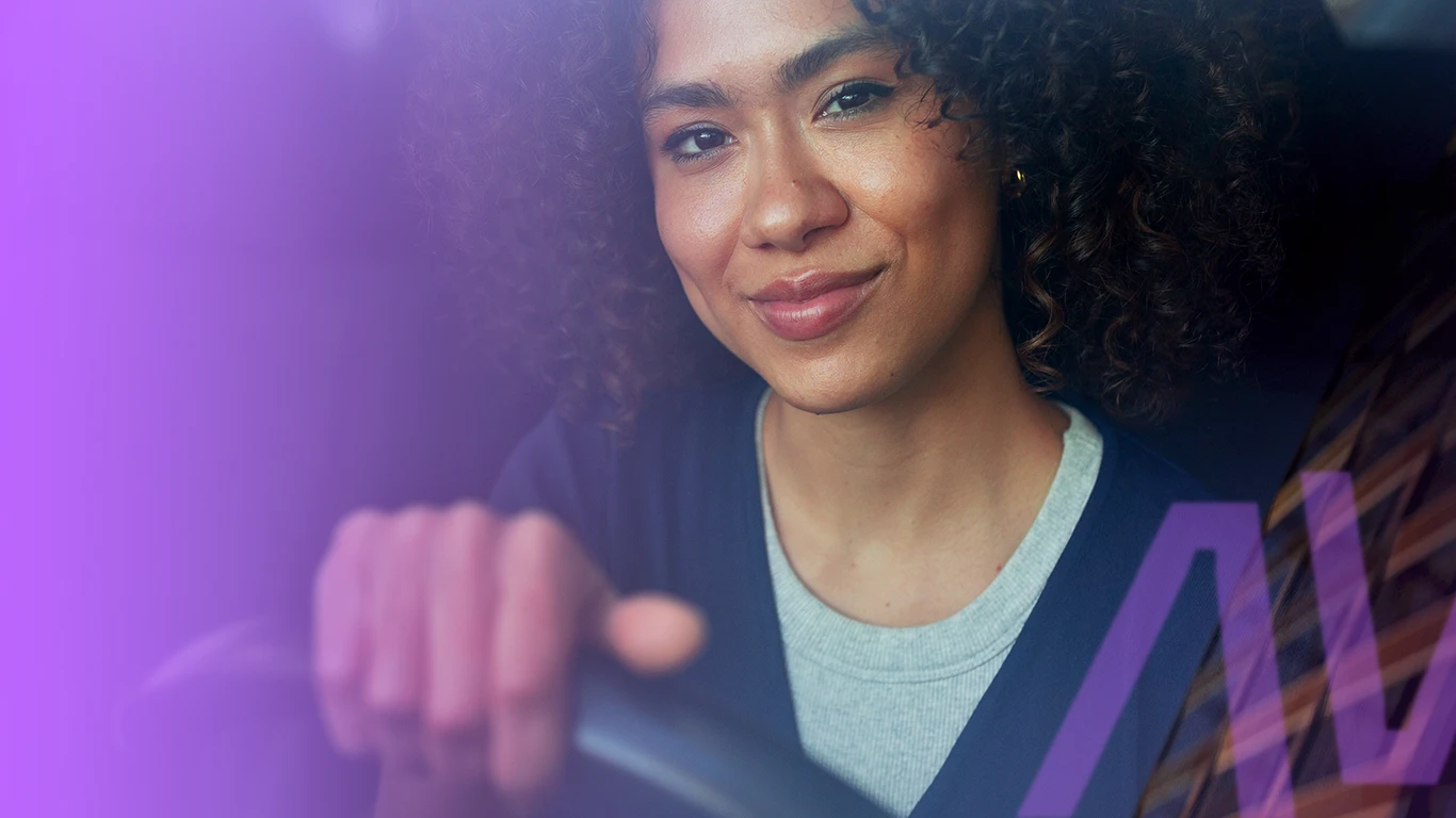 Mulher sorrindo ao volante de um carro